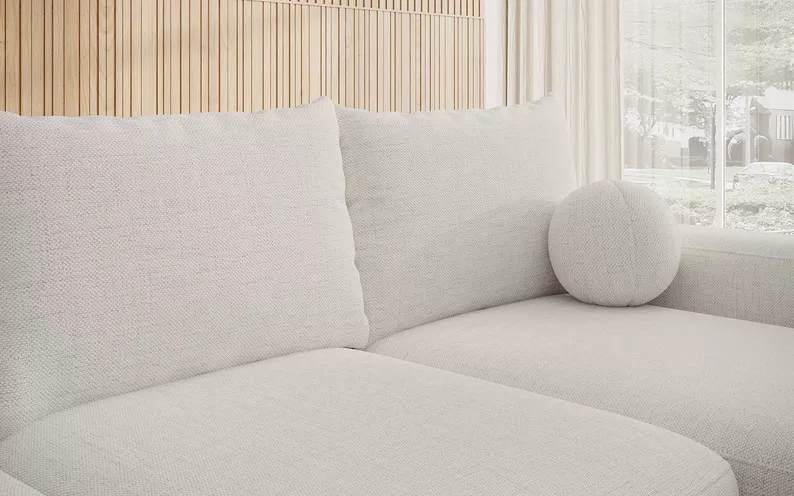 Ecksofa mit Schlaffunktion Carnos L-förmig mit Ball, einzelne Kissen in cremefarbenem hydrophobem Chenille, rechtsseitig.